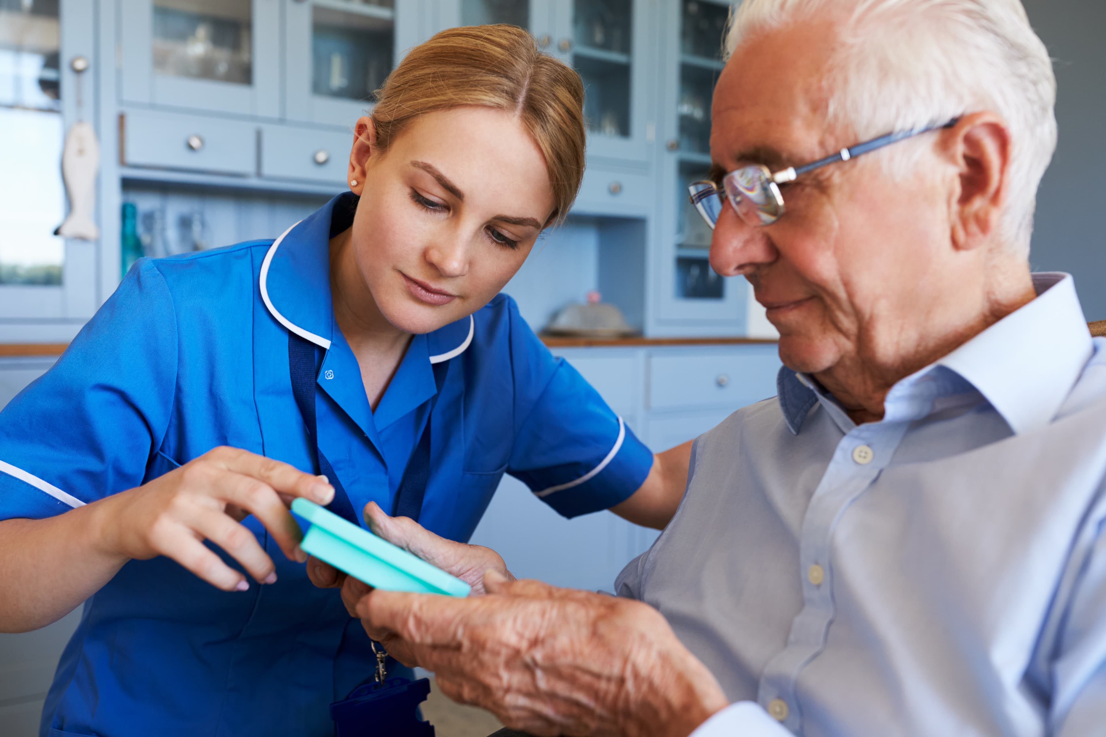 A caregiver assisting an older adult at home